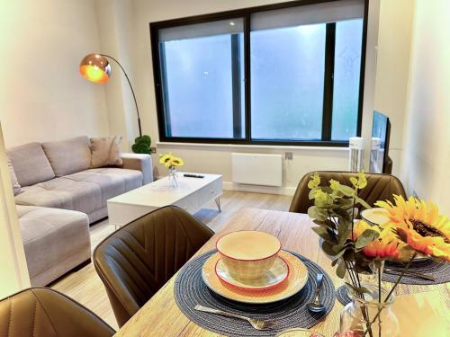 un soggiorno con tavolo, sedie e divano di Charming 1-Bedroom Haven near The Shard in Elephant & Castle a Londra