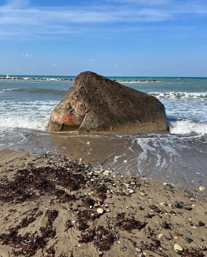 a large rock in the water on a beach at Mountain View Apartment - Polis in Polis Chrysochous