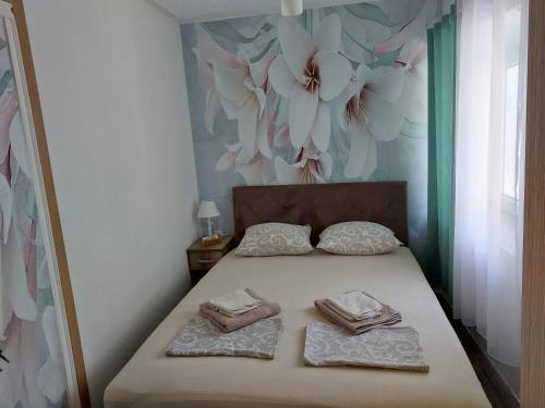 a bedroom with a bed with two towels on it at Vicky Apartments in Kotor