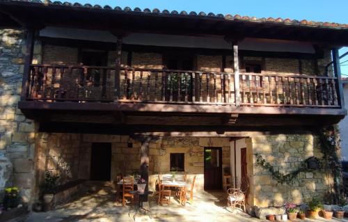 un edificio con balcone, tavolo e sedie di Posada La Dalia a Castillo-Pedroso