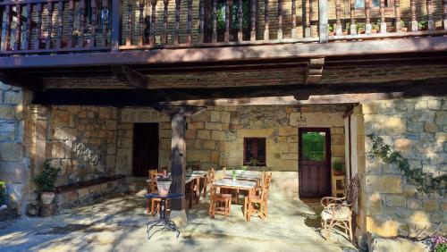 un patio con mesa y sillas bajo un balcón en Posada La Dalia, en Castillo-Pedroso
