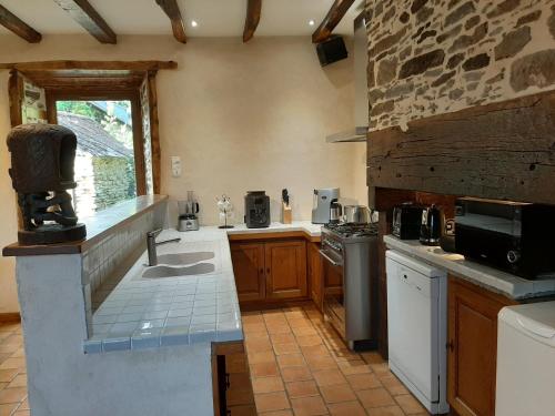 Il comprend une grande cuisine équipée d'un évier et d'une cuisinière. dans l'établissement Gite des papous Meublé de tourisme 4 épis, à Saint-Jal