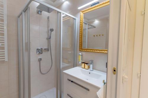 a bathroom with a shower and a sink and a mirror at CT-GOLD Penthouse Bodensdorf Amatera privater Seezugang Hallenbad, Skiarena Gerlitzen in Bodensdorf