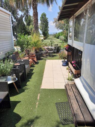 - un jardin avec un banc, une table et des chaises dans l'établissement Grand Mobilhome, à Hyères