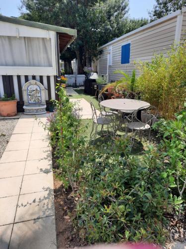 un patio avec une table et des chaises dans une cour dans l'établissement Grand Mobilhome, à Hyères
