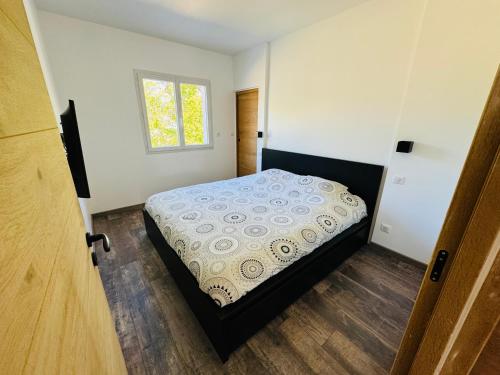 - une chambre avec un lit dans une pièce dotée d'une fenêtre dans l'établissement Maison au Pays Basque 6p, à Boucau