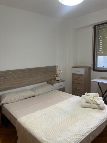 1 dormitorio con 2 camas, mesa y ventana en Disfruta de Exclusiva habitación privada, A 5 minutos de la playa en Vigo en Vigo