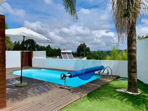 una piscina con un tobogán azul junto a una casa en VN MOUNTAIN VIEWS PORTO, en Sanguedo