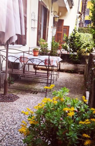 a patio with a table and chairs and flowers at Residenza Esse in Angera