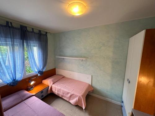 Habitación pequeña con cama y ventana en Appartamenti Levante - Agenzia Cocal, en Caorle