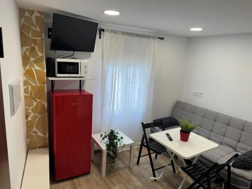 a living room with a couch and a tv on a red cabinet at Checkmate in Tolox