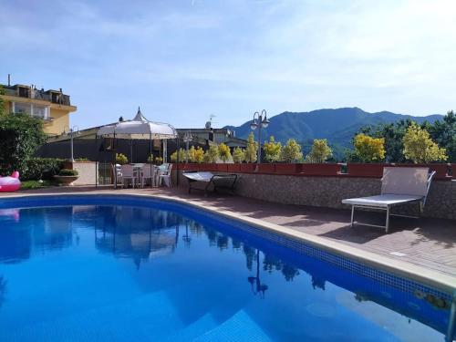 a blue swimming pool with a table and chairs at Villa Elvira in Pellezzano