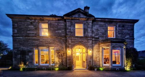 an old stone house with a yellow door at The Pines Guest House in Elgin