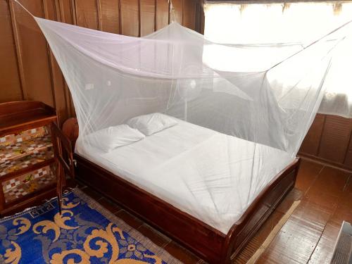 a bedroom with a bed covered in mosquito net at Hotel Germain - Ganvié Holiday Resort in Ganvié