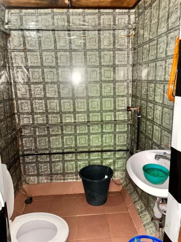 a bathroom with a bucket of money on the floor at Hotel Germain - Ganvié Holiday Resort in Ganvié