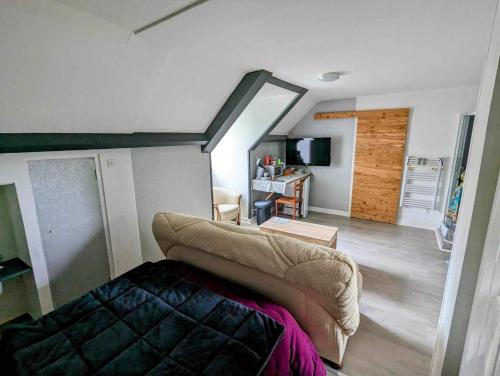 Habitación con sofá y sala de estar. en Chez madame loic en Fère-Champenoise