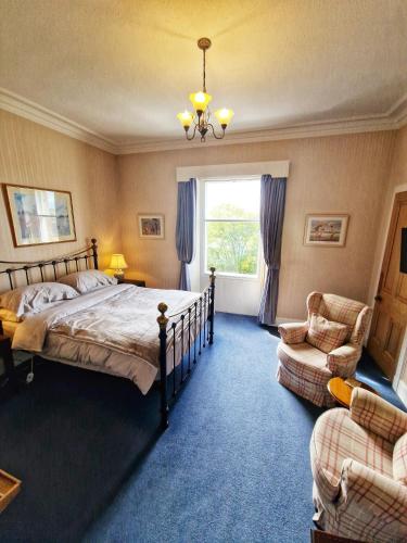 a bedroom with a bed and a chair and a window at The Pines Guest House in Elgin