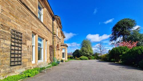 a brick building with a bench in front of it at The Pines Guest House in Elgin