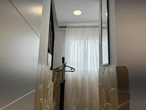 een glazen deur die leidt naar een douche met een gordijn bij Checkmate in Tolox