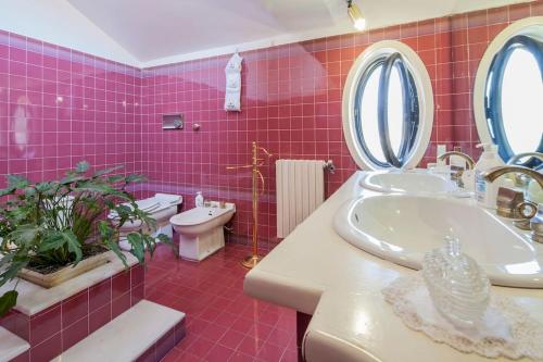 een roze badkamer met een wastafel en een toilet bij Villa Elvira in Pellezzano