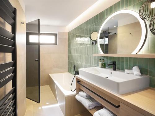 a bathroom with a sink and a mirror at Hotel Bütgenbacher Hof in Butgenbach