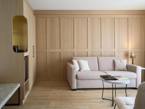 a living room with a white couch and a table at Hotel Bütgenbacher Hof in Butgenbach