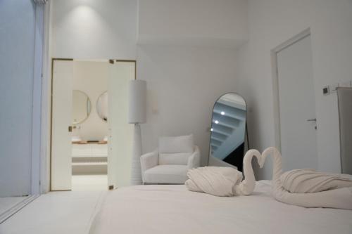 a white room with a bed and a mirror at אגם החלומות in Neve Zohar