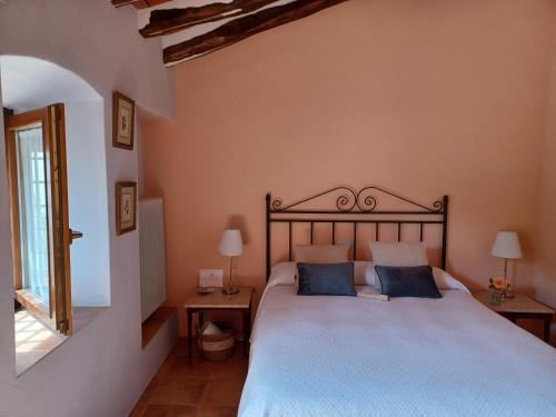 a bedroom with a large bed with blue pillows at Casa del Riu in Benejama
