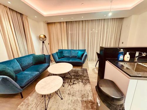 a living room with a blue couch and tables at Luxury 2 Bedroom Apartment in Old Street, London in London