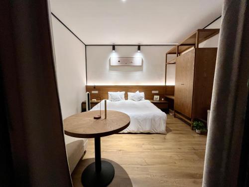 sypialnia z łóżkiem i stołem w pokoju w obiekcie Dalifornia Courtyard Retreat w mieście Dali