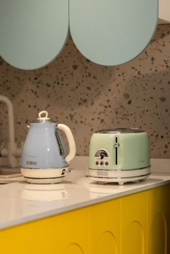 a tea kettle and toaster sitting on a kitchen counter at Teal Guesthouse in Batroûn