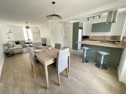a kitchen and living room with a wooden table and chairs at La Grenouillère in Brie-Comte-Robert