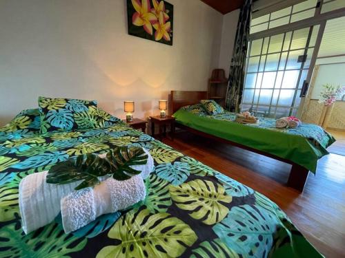 1 dormitorio con 2 camas con edredones verdes en TE REKA LODGE vue mer, en Mahina