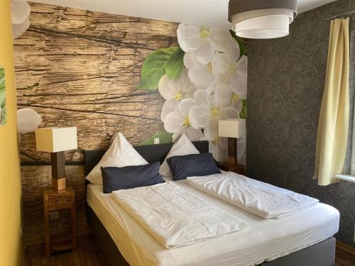 a bedroom with a bed with flowers on the wall at Haus Schwarzenberg in Ernst