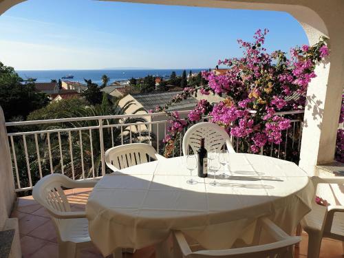 - une table et des chaises blanches sur un balcon fleuri dans l'établissement Gordy Hart of the Center Novalja with Pool, à Novalja