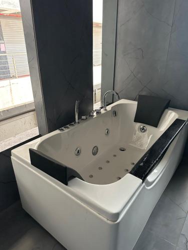 a white bath tub in a bathroom with a window at Hotel victoria prime in Surat