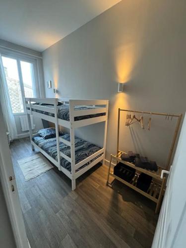 une chambre avec deux lits superposés et un miroir dans l'établissement Belle maison médocaine, à Saint-Julien-Beychevelle