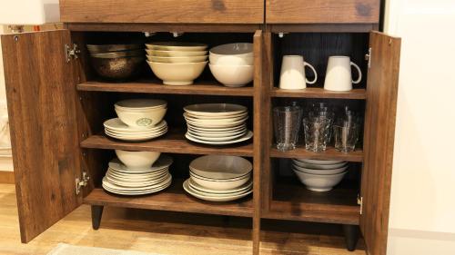 a cabinet filled with plates and bowls and dishes at Ayanishiki大阪西九条STAY in Osaka