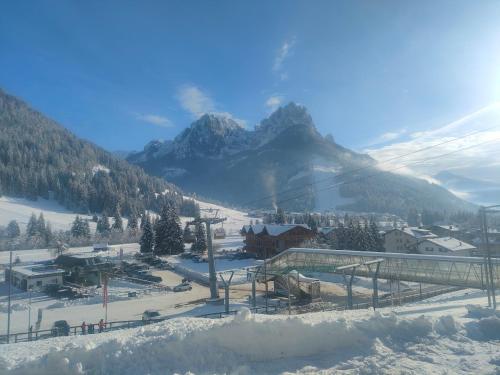 a ski resort with a mountain in the background at appartamento PANORAMA in Pozza di Fassa
