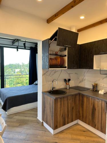 Una cocina con fregadero y una cama en una habitación. en Agora Sundeck Tsikhisdziri, en Tsikhisdziri