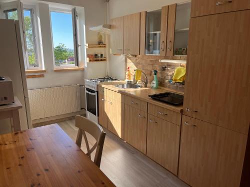 a kitchen with wooden cabinets and a wooden table with a wooden floor at Chateau view apartment Mikulov in Mikulov