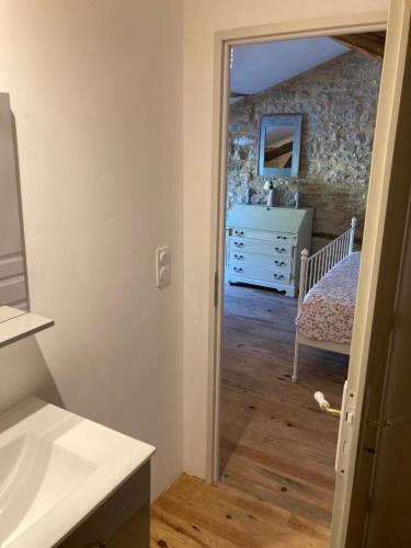 La salle de bains est pourvue d'une chambre avec un lit et un miroir. dans l'établissement Chambre avec salle de bain, à Caylus