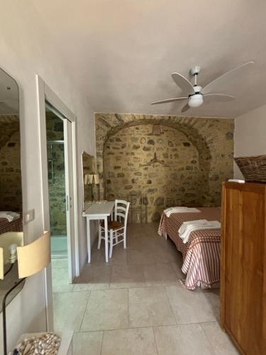 a bedroom with two beds and a table in a room at Casa castello in Rocca Imperiale