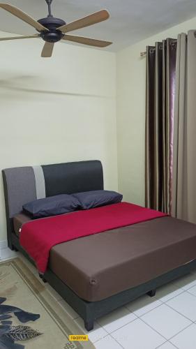 uma cama num quarto com uma ventoinha de tecto em d'zam residensi seri serindit em Bukit Baru