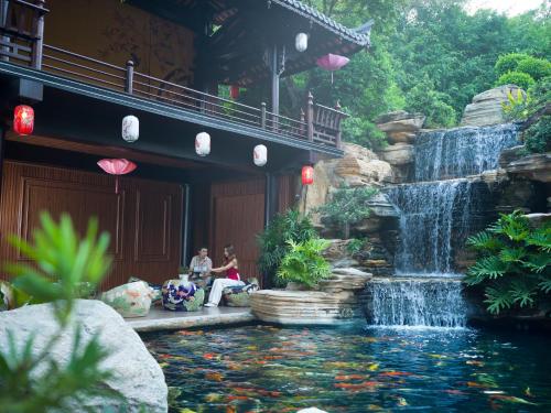 a waterfall in the middle of a koi pond at Phuong Nam Resort in Thuan An