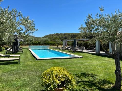 une piscine au milieu d'une cour herbeuse dans l'établissement Mas Serena, à Ménerbes