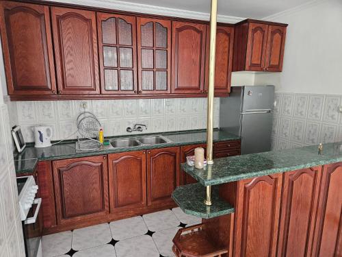 une cuisine avec des armoires en bois et un évier dans l'établissement Lazur SeaView Apartment, à Pomorie
