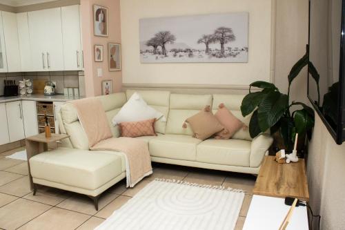Neapolitan Guesthouse في ألبرتون: غرفة معيشة مع أريكة بيضاء وكرسي