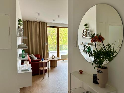 a living room with a mirror and a living room with a couch at Forest Zen Sopot z widokiem na morze - Praia Apartments - Polsat Plus Arena in Sopot
