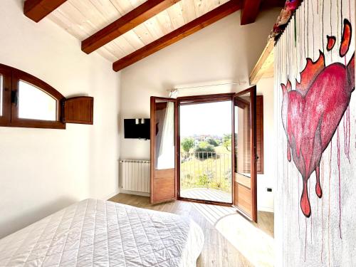 ein Schlafzimmer mit einem Herzwandbild an der Wand in der Unterkunft Apartments MADEJ 3 in Bari Sardo